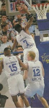 Ron Anderson au dunk entouré de Michael Ray Richardson et Tim Kempton. (c) J-f Mollière